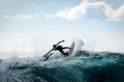 Young surfer with with wetsuit enjoying big waves in tenerife, canary islands. sporty boy waves