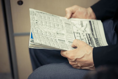 Close-up of hand holding newspaper