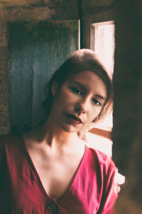 Portrait of woman by window at home