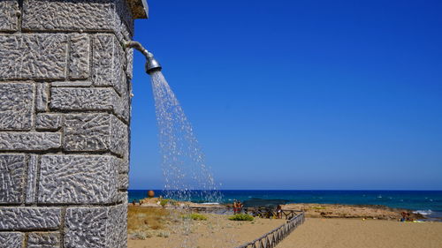Scenic view of beach against clear blue sky