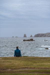 Man seated enjoying the view of the coastline at bonavista, newfoundland, canada