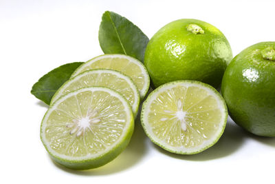 Close-up of green fruits against white background