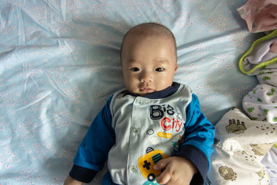 Portrait of cute baby lying on bed