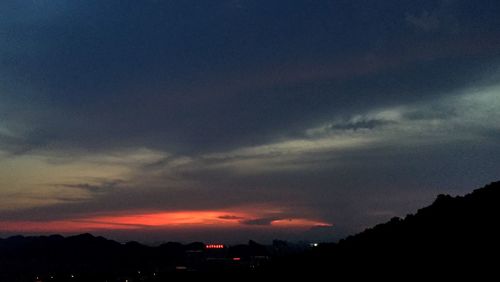 Silhouette of trees against dramatic sky