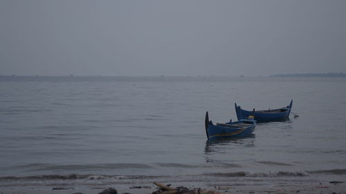 Boat moored in sea against clear sky