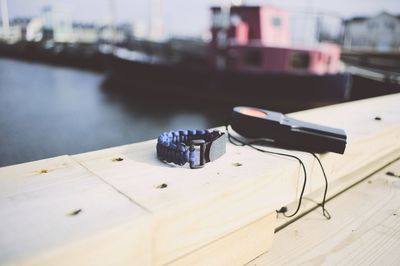 Parachute cord bracelet with equipment on wooden railing at harbor