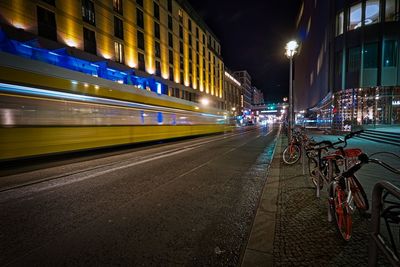 Blurred motion of train on street in city at night