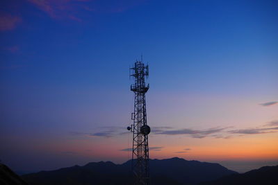 Low angle view of communications tower against sky during sunset