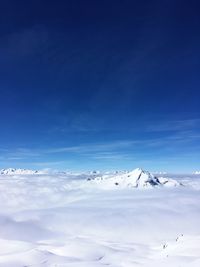 Scenic view of snow mountains against blue sky