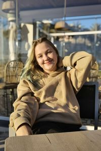 Portrait of young woman sitting on sofa at home