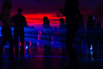 Silhouette people in illuminated shopping mall