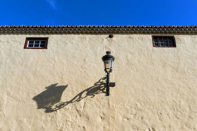 Low angle view of gas slight on building wall during sunny day