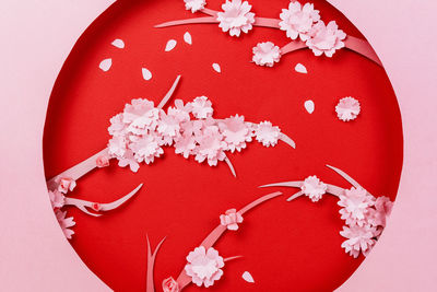 High angle view of red flower petals against white background