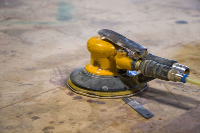 Yellow sander close-up on the table, dirty sander