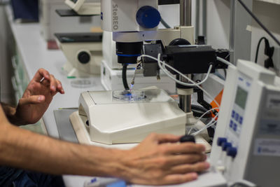 Midsection of doctor examining chemical in laboratory