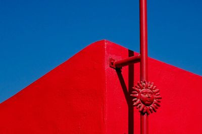Close-up of red built structure against blue sky
