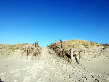 Panoramic view of desert against clear blue sky