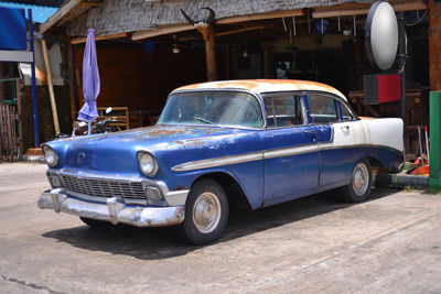 Vintage car on street against buildings in city