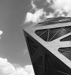 Low angle view of modern building against cloudy sky