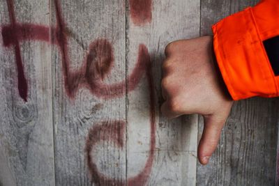 Close-up of hands against orange wall