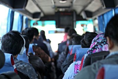 Rear view of men looking at bus