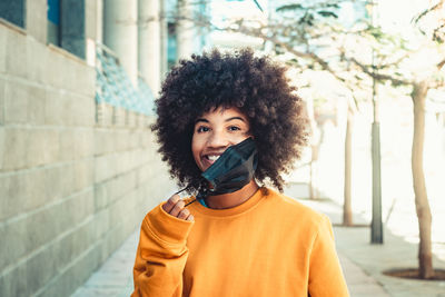 Portrait of beautiful woman standing against wall