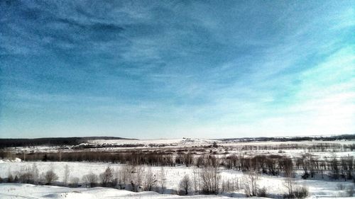 View of frozen landscape against blue sky
