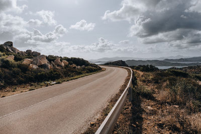 Road leading towards landscape against sky