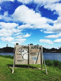 Information sign against cloudy sky