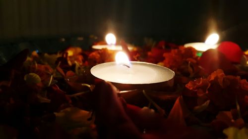 Close-up of lit candle in dark room