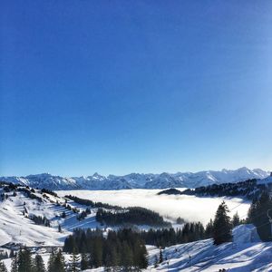 Scenic view of snowcapped mountains against clear blue sky