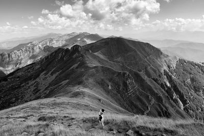 Woman hiking on grassy field against sky