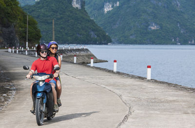 Young couple exploring cat ba island on a motor scooter