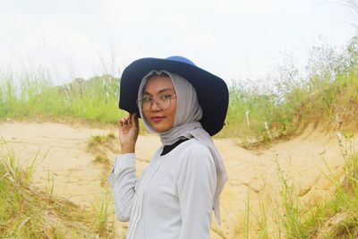 Portrait of smiling young woman standing on field