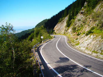 Road amidst mountains against clear sky