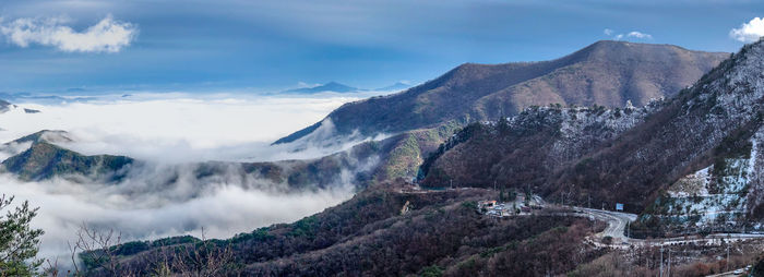 Scenic view of mountain range against cloudy sky