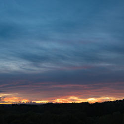 Silhouette of landscape against cloudy sky