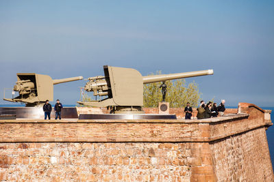 People in front of built structure against clear sky