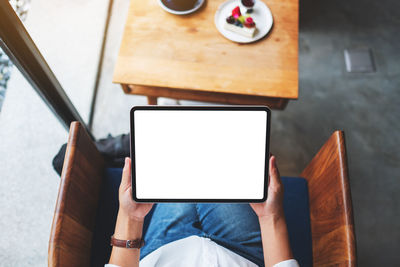 High angle view of woman using digital tablet on table