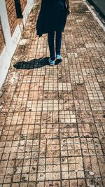 Low section of woman walking on sidewalk