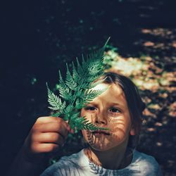 High angle view of girl holding leaf while standing outdoors