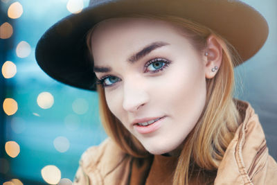 Close-up portrait of beautiful young woman wearing hat