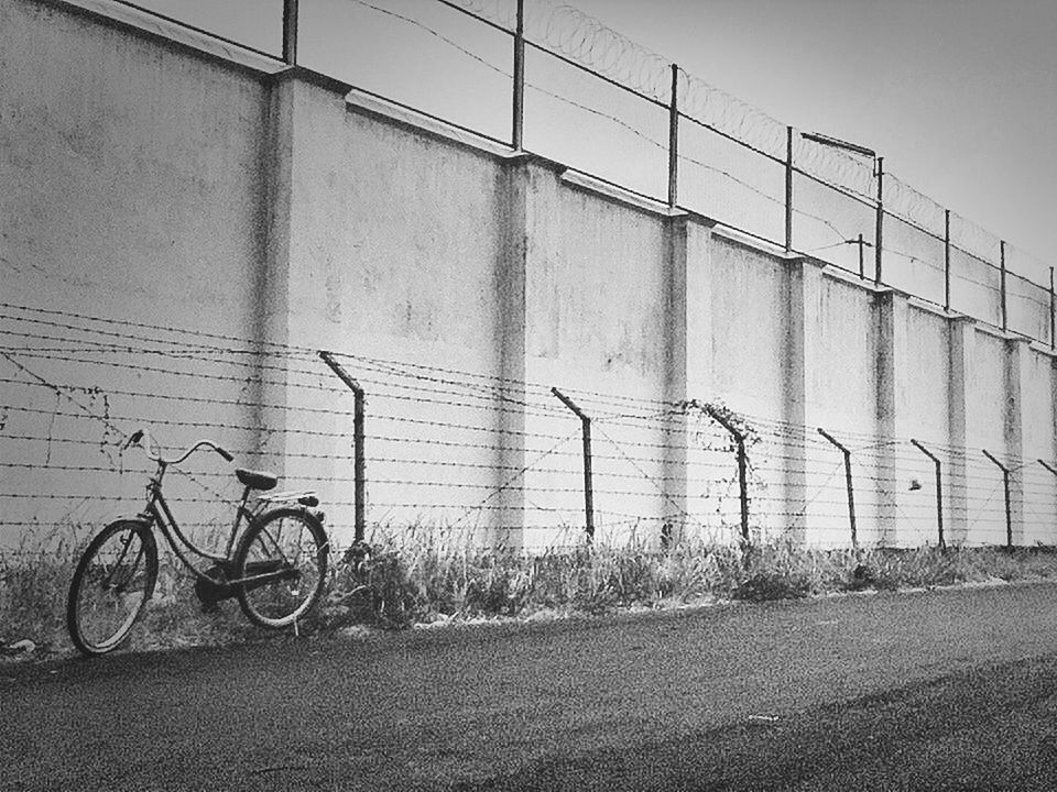 bicycle, transportation, architecture, built structure, building exterior, land vehicle, mode of transport, parked, stationary, parking, wall - building feature, street, day, road, city, outdoors, wall, cycle, building, no people