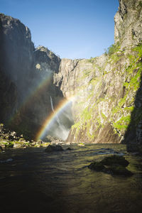 View of rainbow over mountain river