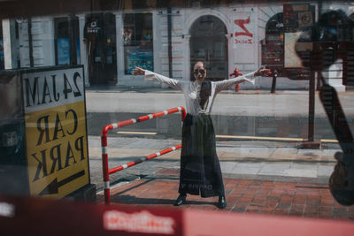 Woman with arms raised in city