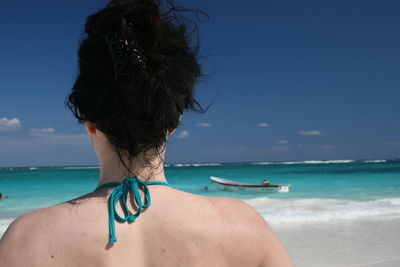 Rear view of man on beach against sky