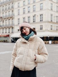 Woman standing against building in city