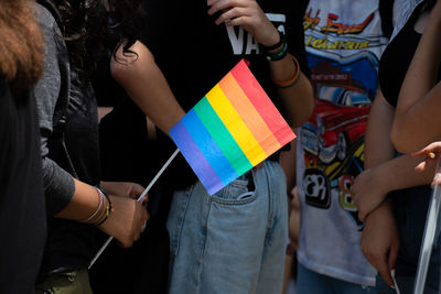 Midsection of woman holding multi colored umbrella