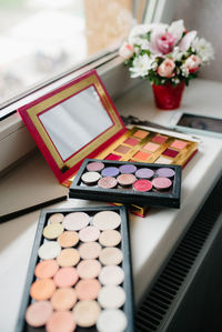 High angle view of eye make up products at the edge of window