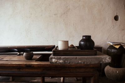 Old bottles on table against wall at home